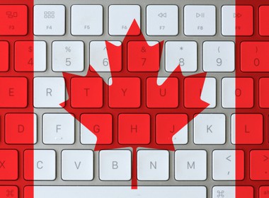 Canadian flag super imposed on the keyboard of a laptop